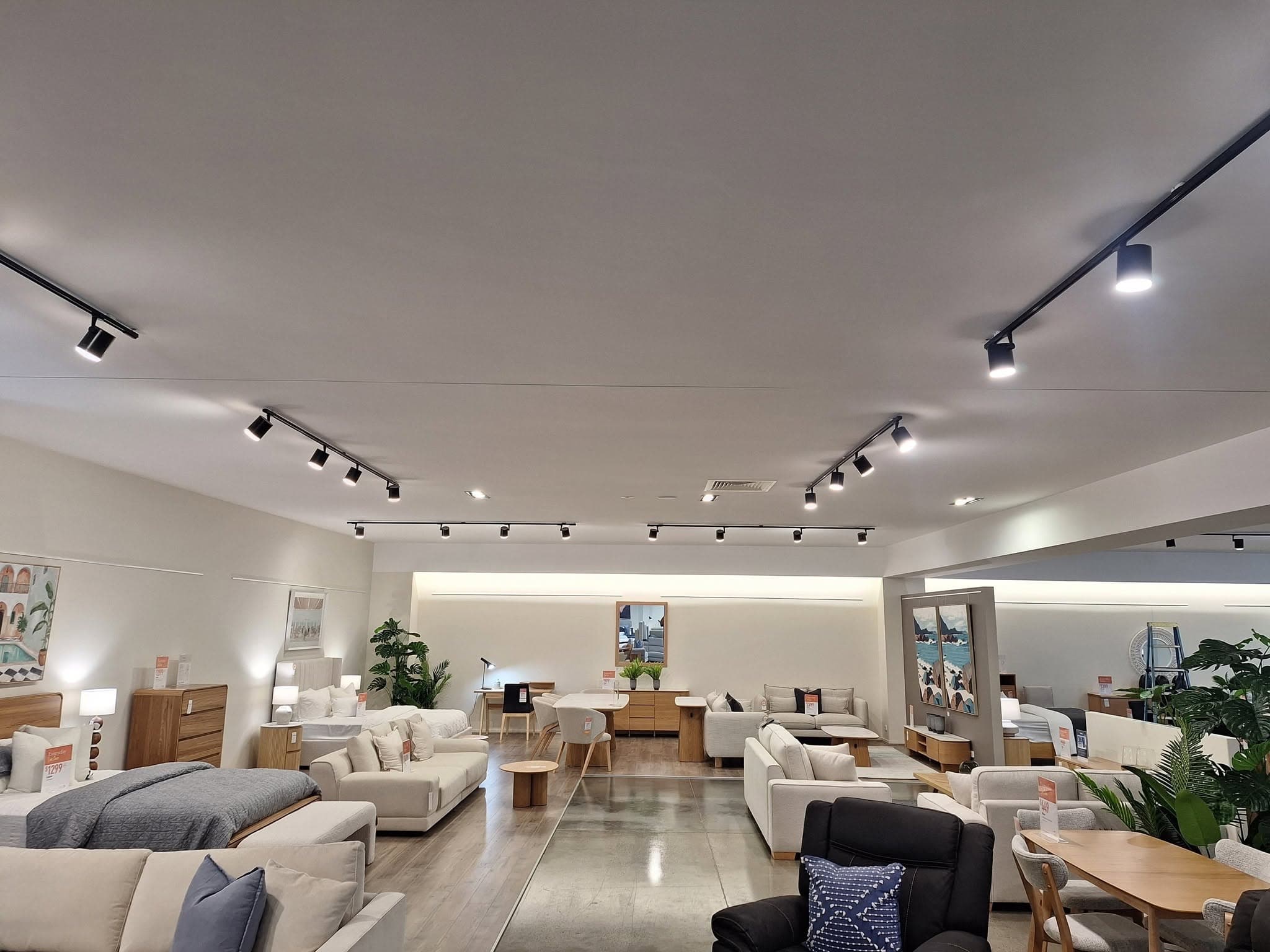 Furniture showroom lit with black track lighting and downlights